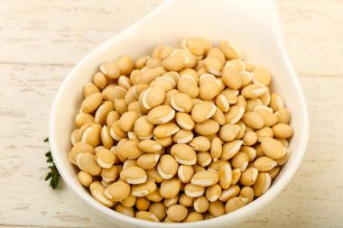 Kase ahşap arka plan üzerinde çiğ beyaz fasulye