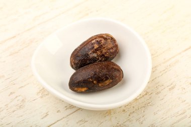 Culinare için iki Nutmegs ahşap arka plan üzerinde kullanın