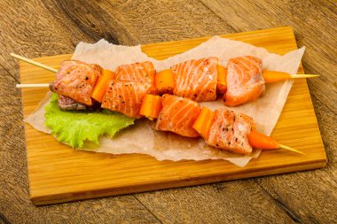 Pişmeye hazır baharatlı çiğ somon şişi.