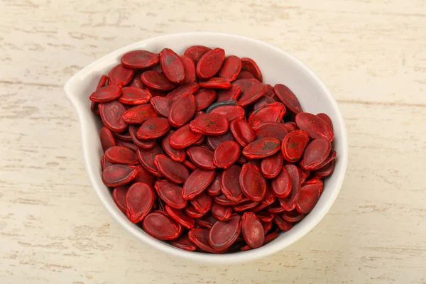 Dry red Pumpkin seeds over wooden background
