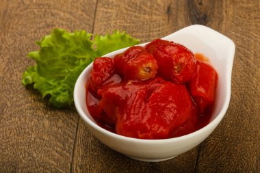 Kase ahşap arka plan üzerinde suyu ile soyulmuş domates