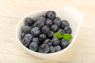 Kase ahşap arka plan üzerinde yabanmersini