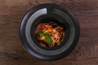 Fesleğen yaprakları ile deniz ürünleri makarna