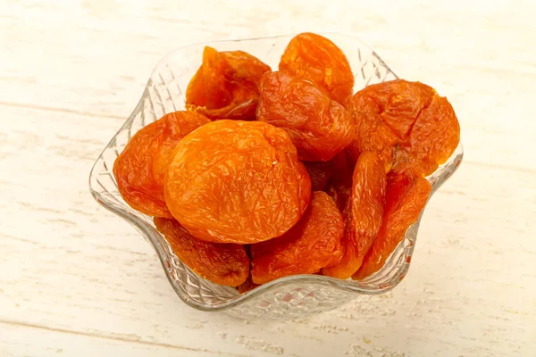 stock image Dried apricots heap in the bowl over wooden background