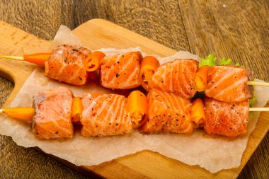 Pişmeye hazır baharatlı çiğ somon şişi.