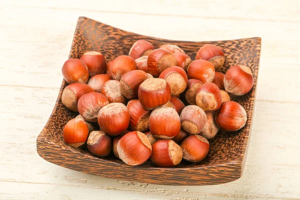 Fındık yığın sepeti ahşap arka plan üzerinde