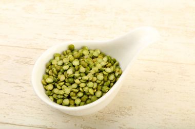 Yeşil bezelye kasede ahşap arka plan üzerinde kazık.