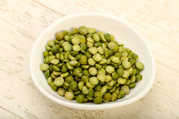 Yeşil bezelye kasede ahşap arka plan üzerinde kazık.