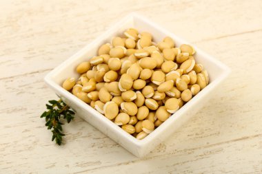 Kase ahşap arka plan üzerinde çiğ beyaz fasulye