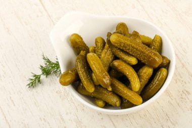 Ahşap arka plan üzerinde kaseye Picled salatalık