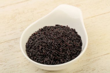 Kase ahşap arka plan üzerinde siyah yabani pirinç