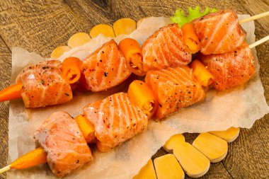 Pişmeye hazır baharatlı çiğ somon şişi.