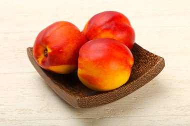 Olgun nektarin yığın ahşap arka plan üzerinde