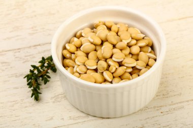 Kase ahşap arka plan üzerinde çiğ beyaz fasulye