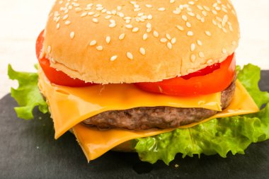 Burger peynir, domates, salata yaprakları ile