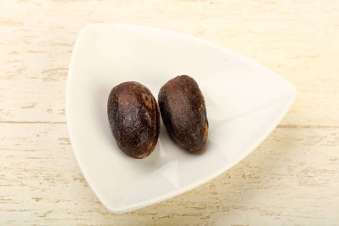 Culinare için iki Nutmegs ahşap arka plan üzerinde kullanın