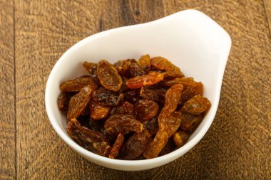 Ahşap arka plan üzerinde kase kuru kuru üzüm