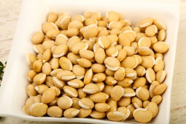 Kase ahşap arka plan üzerinde çiğ beyaz fasulye