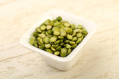 Yeşil bezelye kasede ahşap arka plan üzerinde kazık.