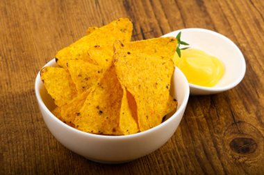 Ahşap arka plan üzerinde peynir soslu cips