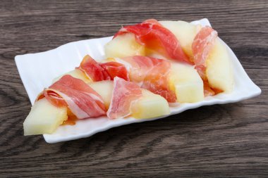 Ahşap arka plan üzerinde prosciutto ile kavun