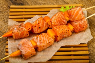 Pişmeye hazır baharatlı çiğ somon şişi.