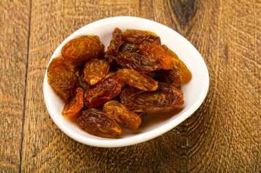 Ahşap arka plan üzerinde kase kuru kuru üzüm