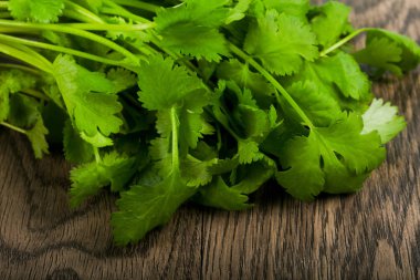 Ahşap arka plan üzerinde kişniş yaprakları