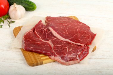 Ham sığır eti biftek ahşap arka plan üzerinde yemek pişirmek için hazır