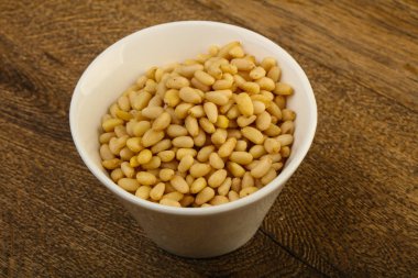 Sedir fındık yığın içinde kase ahşap arka plan üzerinde