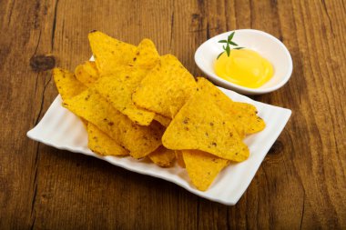 Ahşap arka plan üzerinde peynir soslu cips