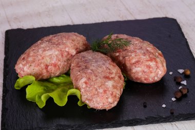 Çiğ Domuz pirzola - kıyılmış et ahşap arka plan üzerinde