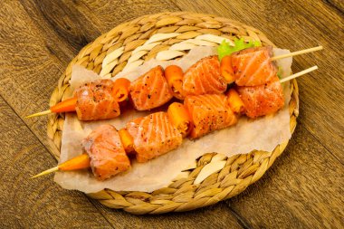 Pişmeye hazır baharatlı çiğ somon şişi.