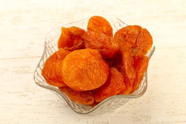 Kuru Kayısı yığın içinde kase ahşap arka plan üzerinde