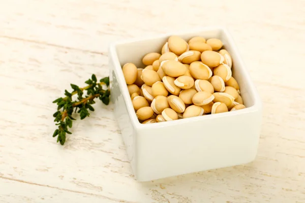 Raw White beans in the bowl over wooden background