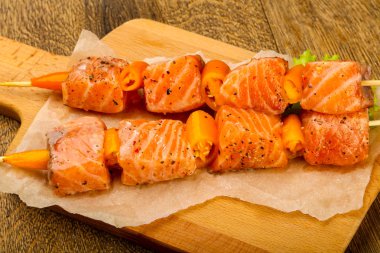 Pişmeye hazır baharatlı çiğ somon şişi.