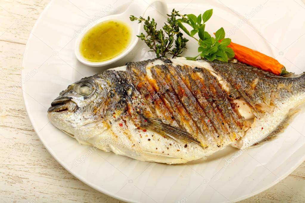 Grilled dorado fish with sauce, thyme and basil