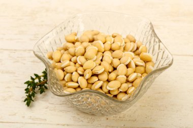 Kase ahşap arka plan üzerinde çiğ beyaz fasulye