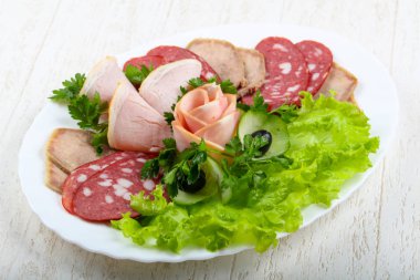 Et ve sosis salata yaprakları ve maydanoz ile karıştırın