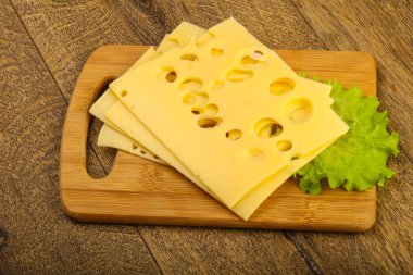 Ahşap arka plan üzerinde dilimlenmiş peynir salata yaprakları