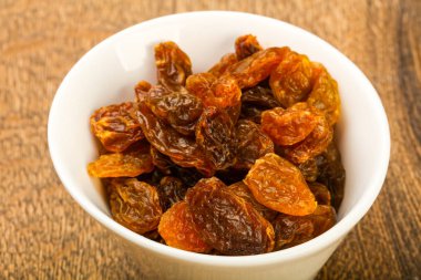 Ahşap arka plan üzerinde kase kuru kuru üzüm