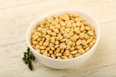 Kase ahşap arka plan üzerinde çiğ beyaz fasulye