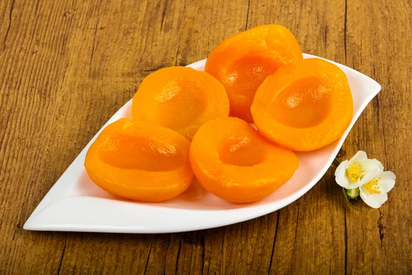 Sweet Canned peaches over wooden background