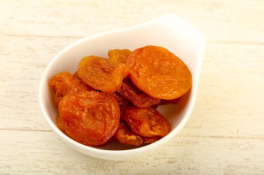 Kuru Kayısı yığın içinde kase ahşap arka plan üzerinde