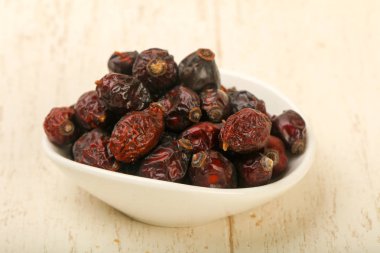 Kuru dogrose yığın ahşap arka plan üzerinde