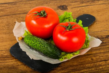 Salatalık ve domates salatası ile ahşap arka plan üzerinde bırakır