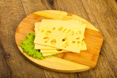 Ahşap arka plan üzerinde dilimlenmiş peynir salata yaprakları