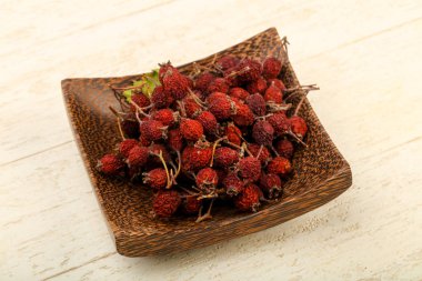 Kase ahşap arka plan üzerinde kuru alıç yığın