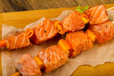 Pişmeye hazır baharatlı çiğ somon şişi.