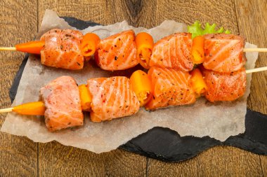 Pişmeye hazır baharatlı çiğ somon şişi.